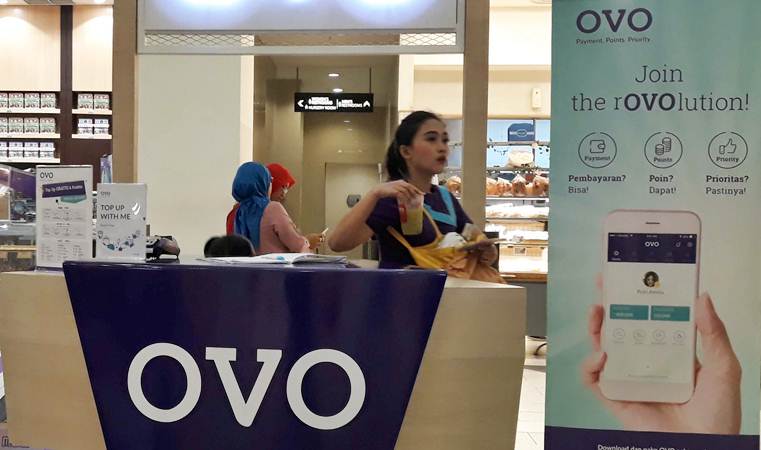 Karyawan melintas di gerai transaksi pembayaran digital OVO, di Jakarta, Senin (25/3/2019). - Foto: Bisnis/Endang Muchtar