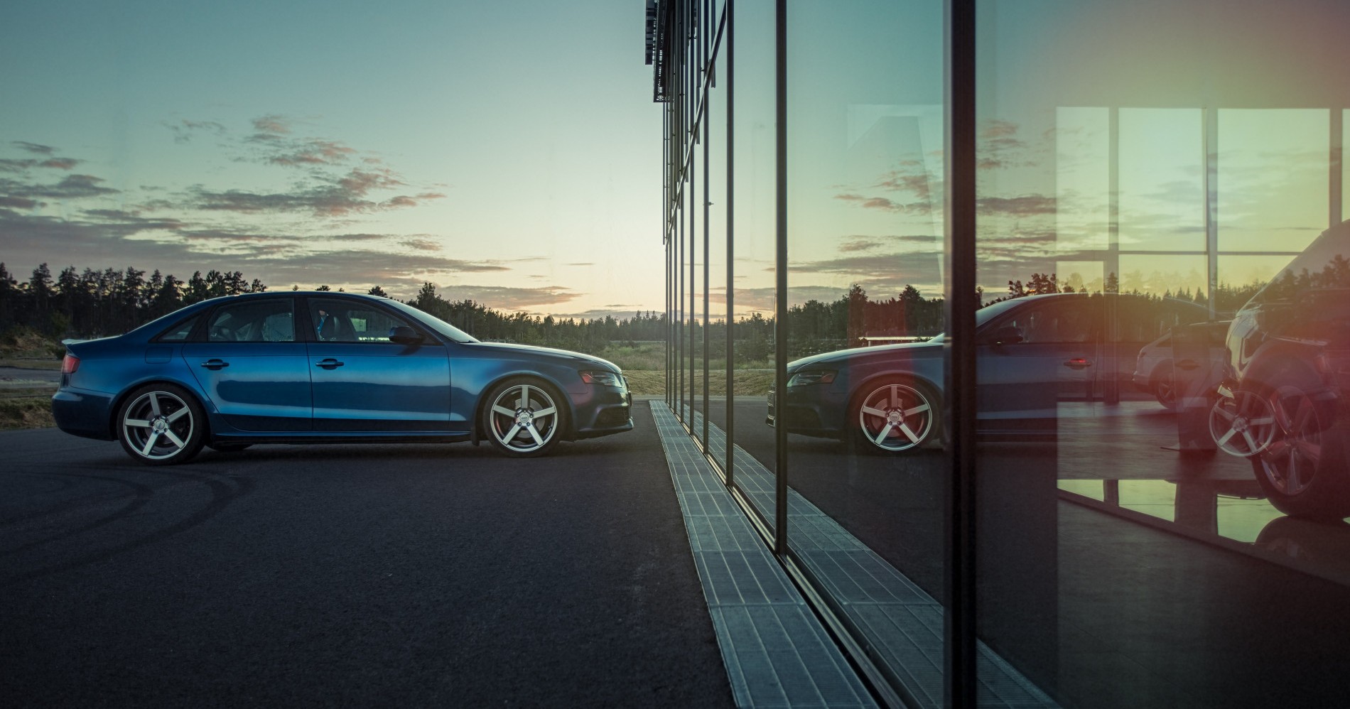 Blue Audi A4 Quattro Saloon Scene with Swedish architecture at dealership (SOURCE : unsplash Arvid Skywalker)